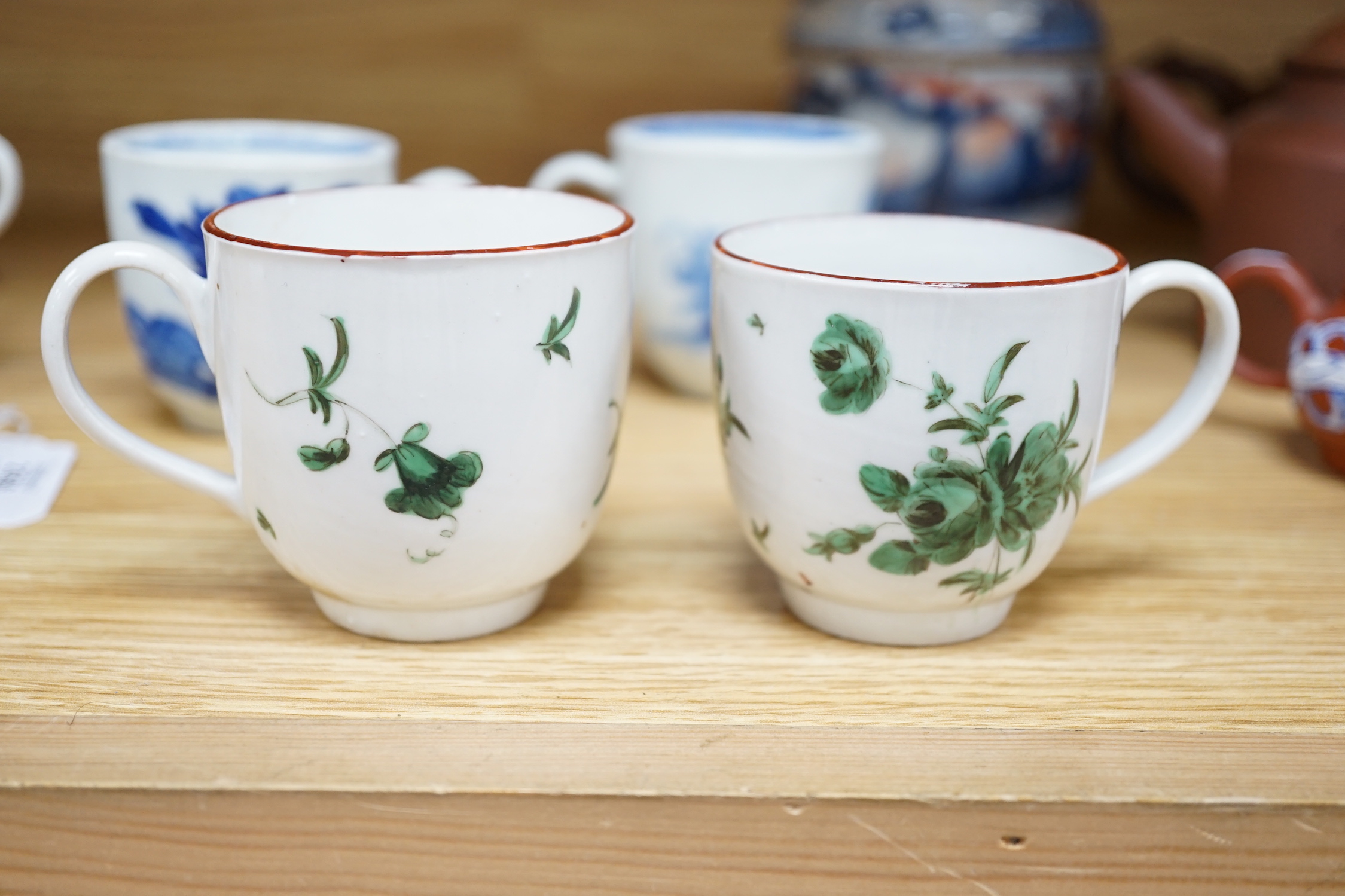 Seven various English porcelain coffee cups, including two Bristol enamelled with green floral sprays, two Bow painted in underglaze blue with a bird in a Chinese garden, and three Worcester/Bow in underglaze blue.